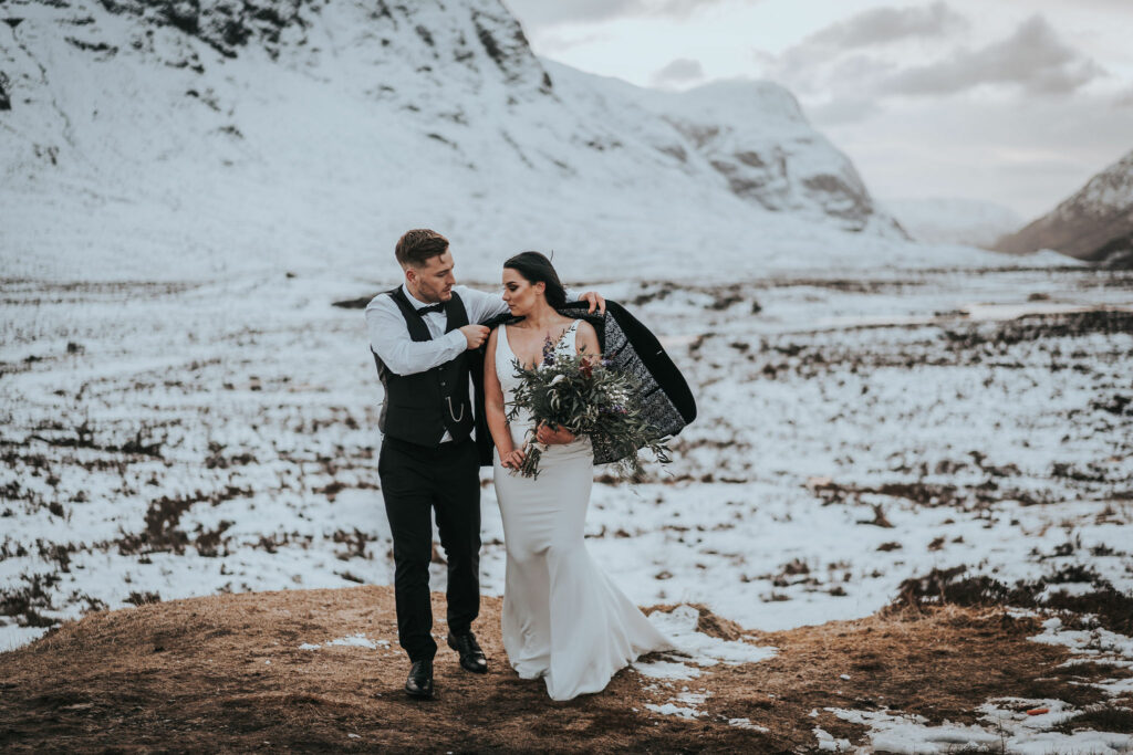 Couple in a snowy valley whilst eloping in the scottish highlands